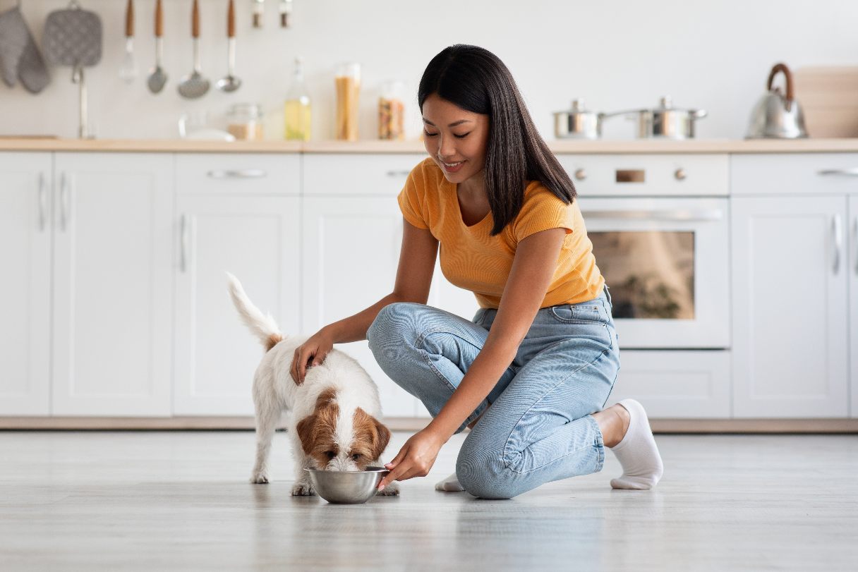 Smiling woman feeding her dog