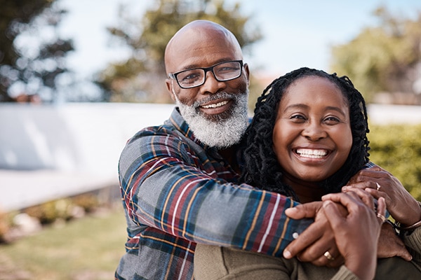 Man with his arms around a woman, both smiling