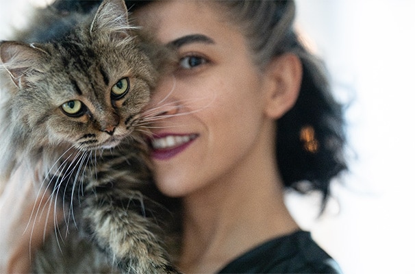 Smiling woman holding a cat against her face