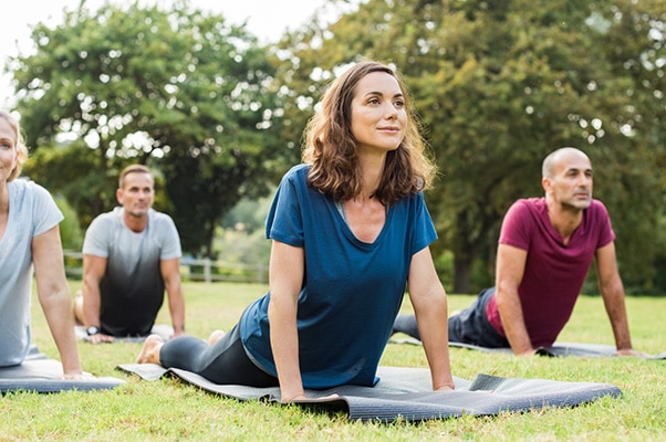 Group of people doing yoga in a park outside