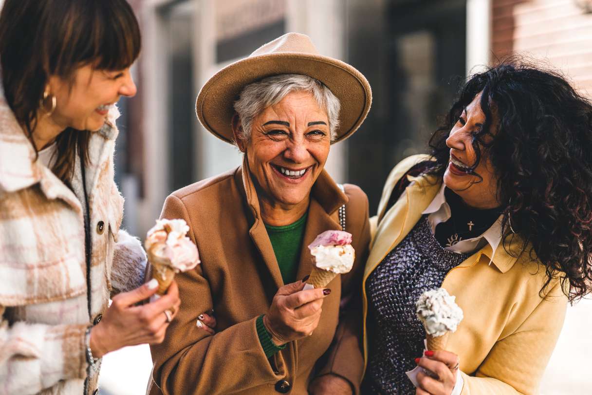 Women smiling and eating ice cream together