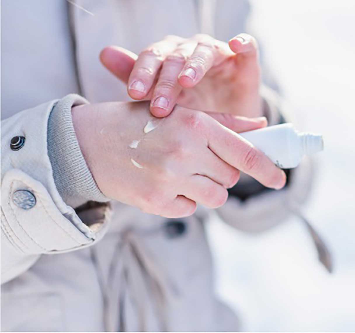 Individual applying cream on their hands