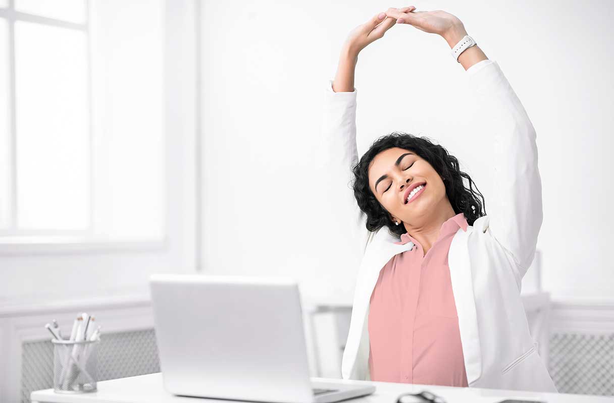 Woman stretching in front of laptop