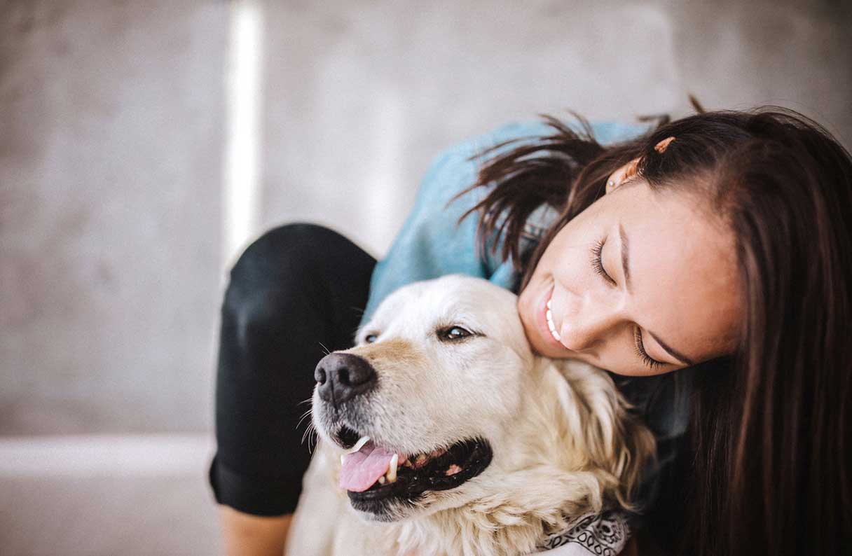 Woman hugging a golden retriever