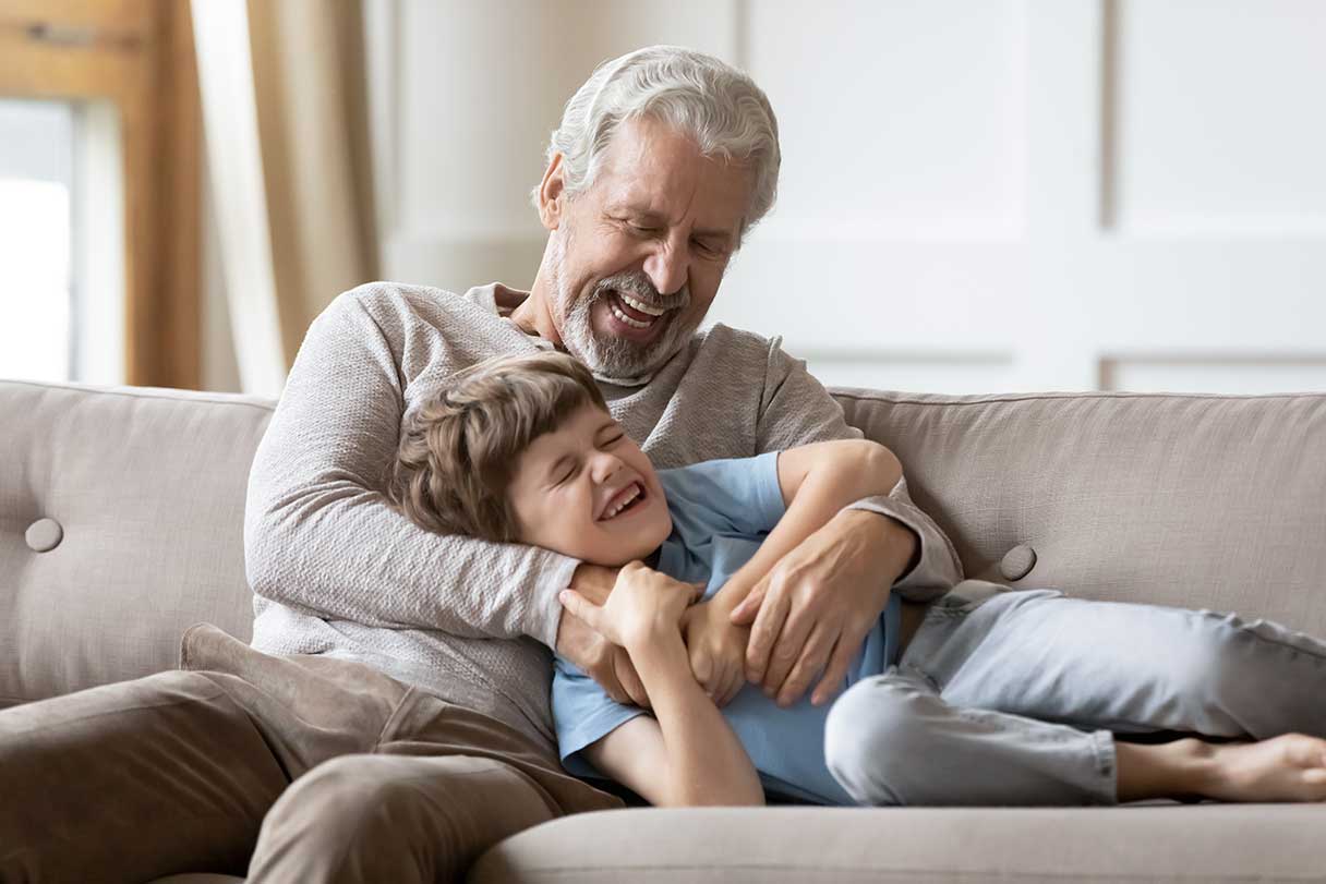 Senior man tickling young boy