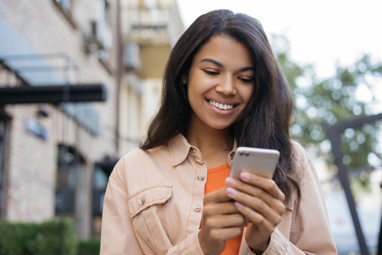 Woman smiling while looking at cellphone screen