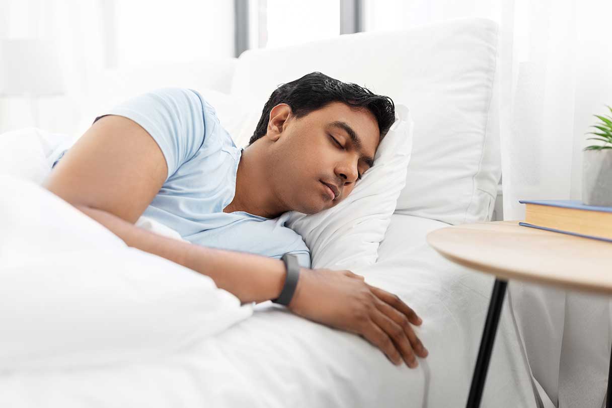 Man sleeping in a bed with white sheets
