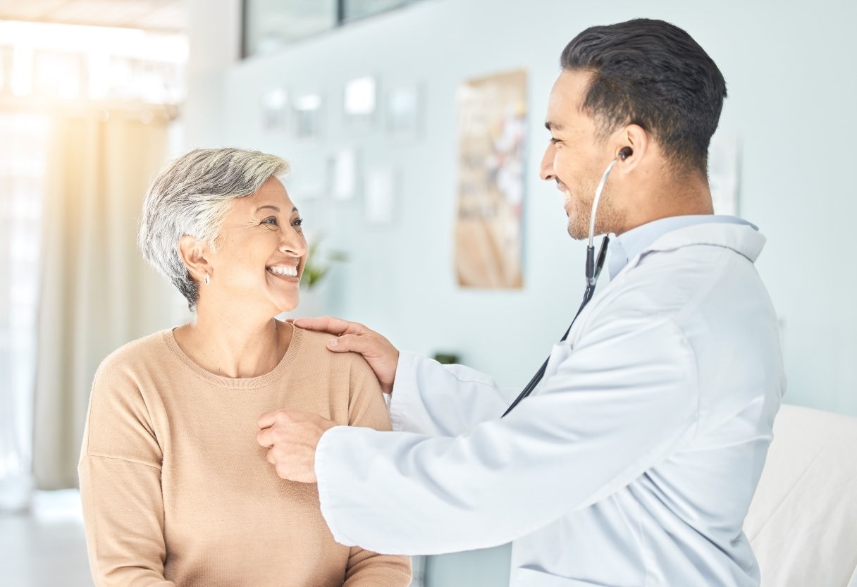 Doctor holding a stethoscope to a woman's chest