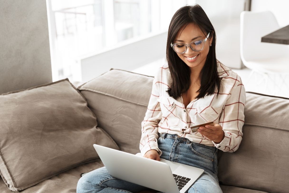 Woman with credit card working on laptop