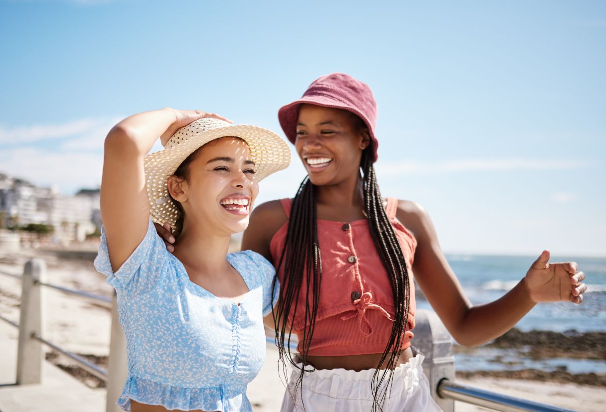 Two women in hats, smiling as they walk outside