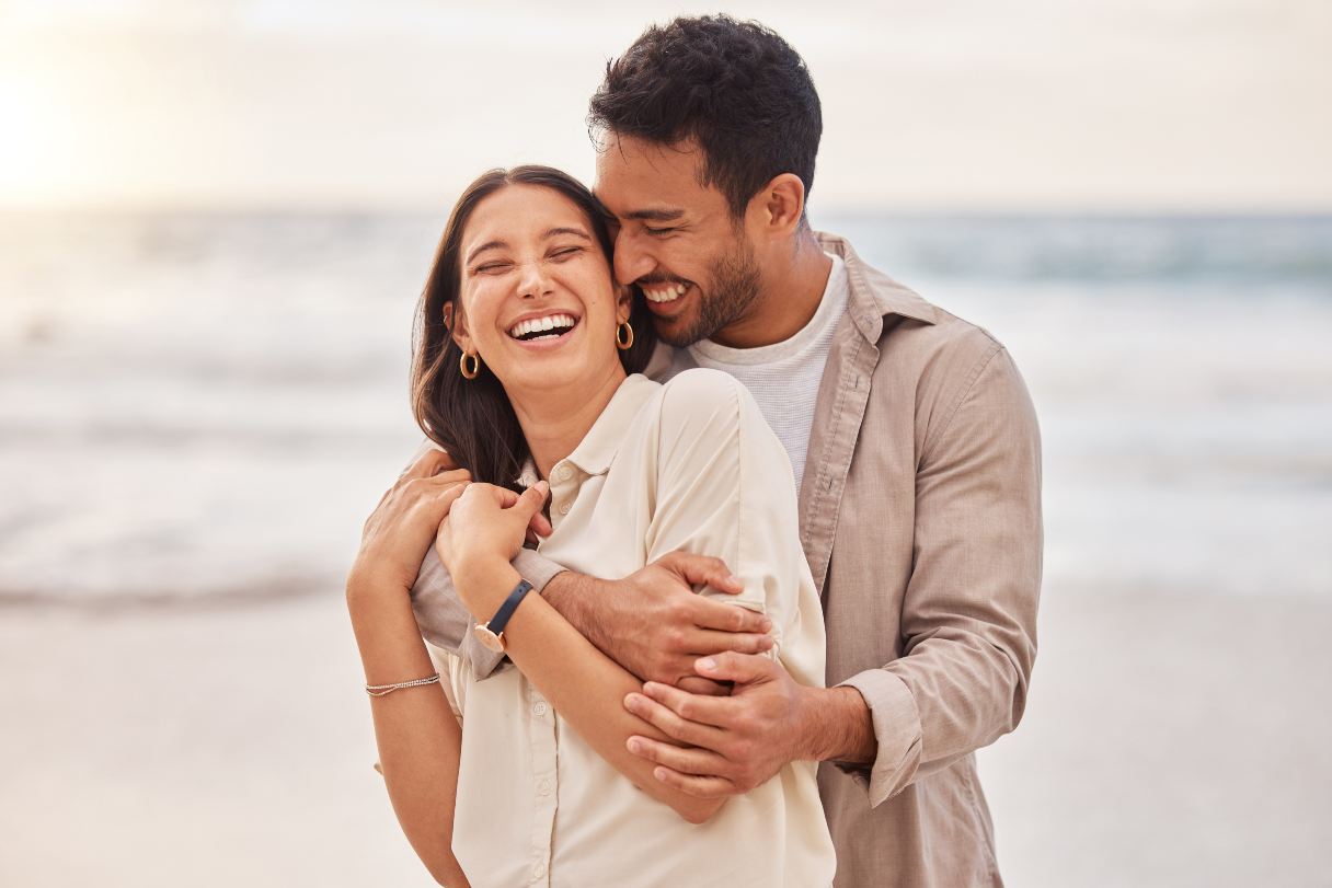 Couple laughing together on a beach