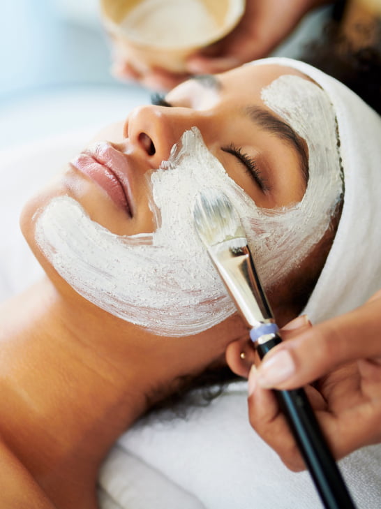 Woman having face mask applied to her skin