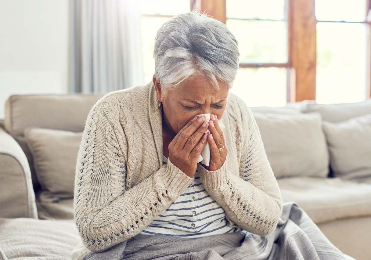 Senior woman blowing her nose