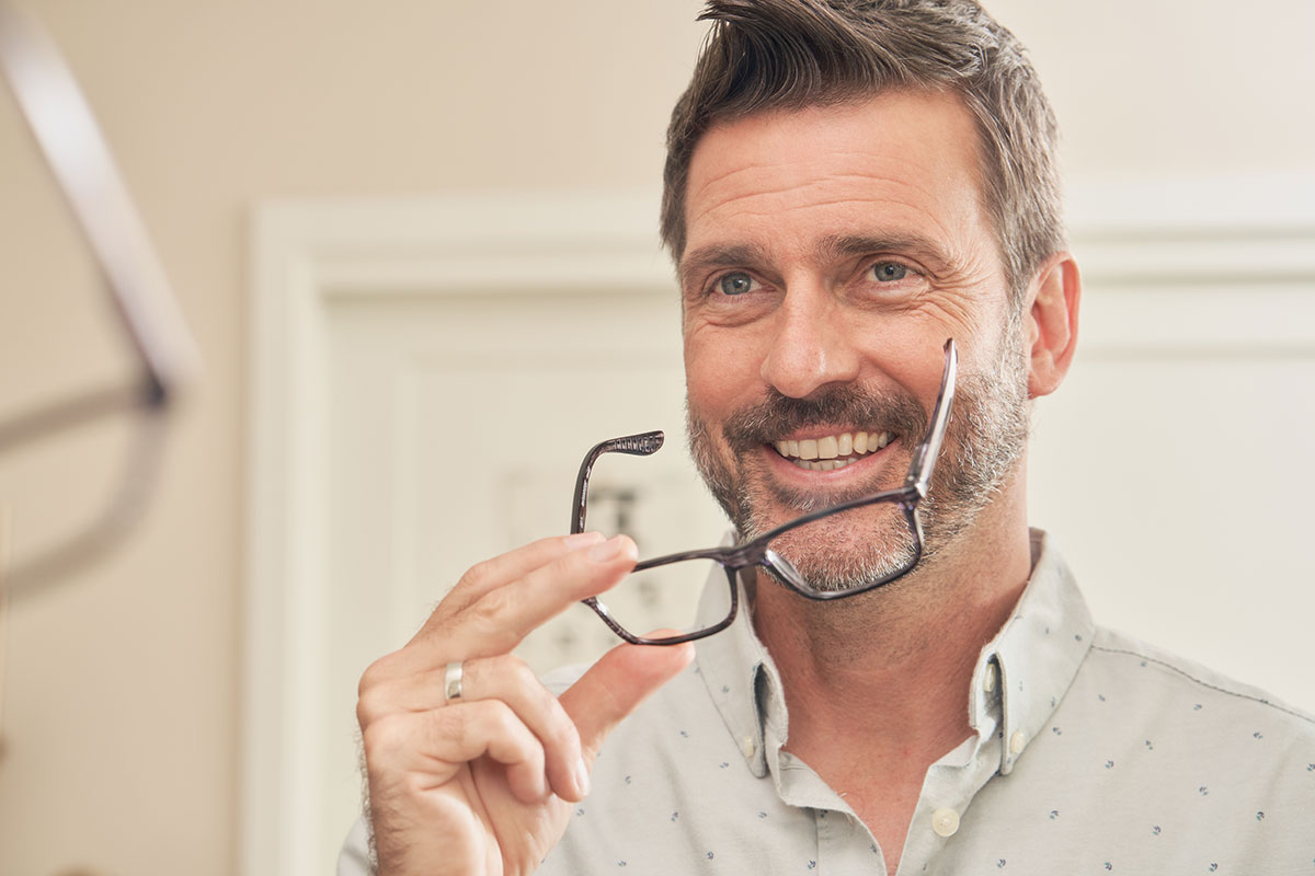 Man putting on glasses