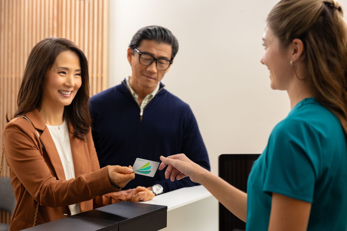 Man and woman using CareCredit credit card to pay at office