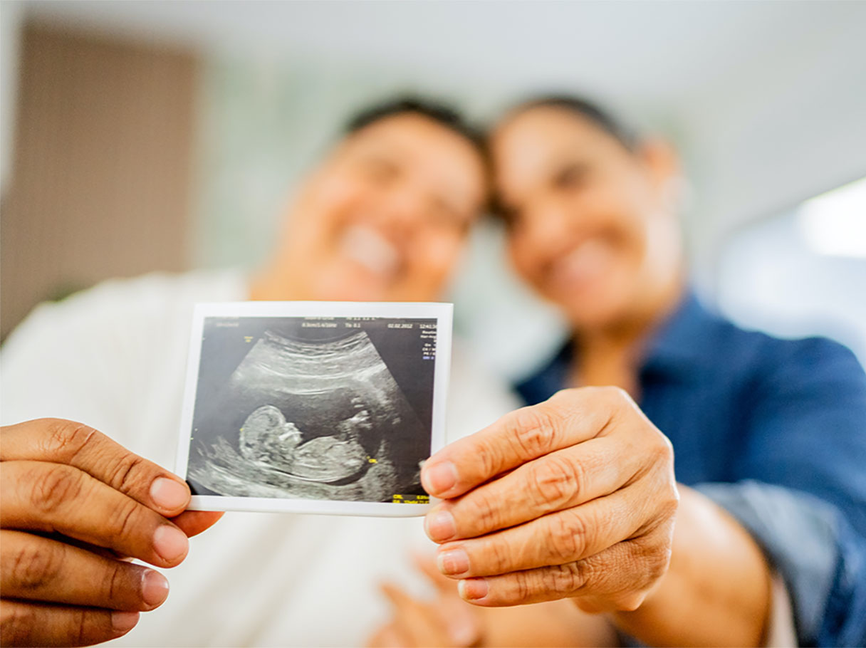 Couple holding a sonogram image, CareCredit credit card