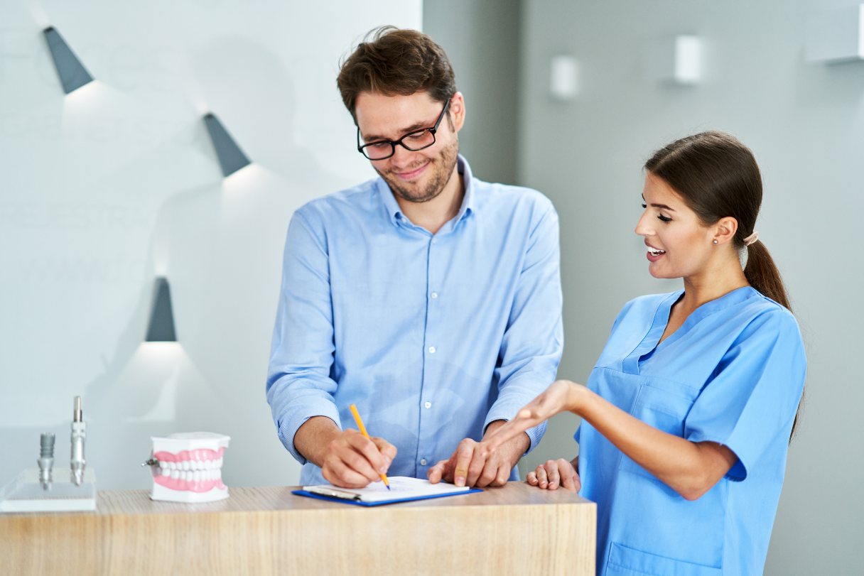 Man filling out form next to woman