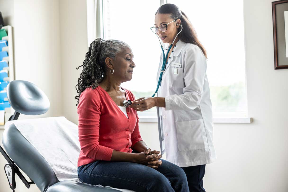 Healthcare provider using stethoscope on patient